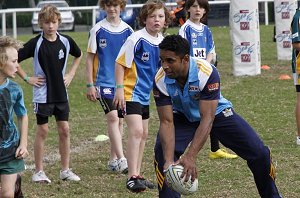 Preston Campbell plays footy with the kids 