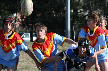 The Sharks player passes the footy despite the attention of the defence