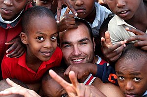 Todd Payten is surrounded by children at Sonshine Boarding School in Rwanda. Picture: Gregg Porteous. / The Daily Telegraph