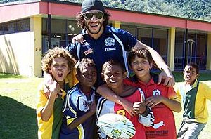 ISLAND TIME ... Johnathan Thurston teaches a few skills to some Palm island kids PHOTO: nqsport.net