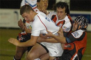 Great Britain forward Jacob Fairbank is gang-tackled by the Territory Titans' enthusiastic defence