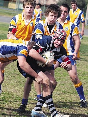 Tom Warner attracts the attention of four defenders during Monday’s University Shield match between Coota High and Warilla High