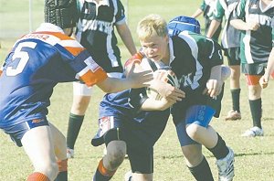 Jordy Holmes battles the Cobar defence led by Brad Harris in yesterday’s Western Area Buckley Shield final.