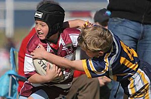 Denman’s Ebony Butler (left) on the attack in his side’s Under 8 clash with Dungowan. Angus Tongue is the tackler. 