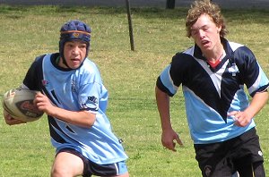 Dave Nicholson from Red Bend runs away from the Aquinas defender